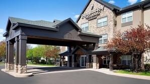 Un edificio con fachada de piedra y un letrero que dice "Country Inn & Suites".