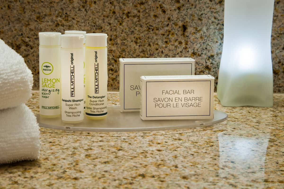 A bathroom counter with various Paul Mitchell hair care products, including shampoos and conditioners.