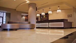 A modern lobby with a reception desk, seating area, and a large pillar. - Courtyard by Marriott Tacoma Downtown (Tacoma)