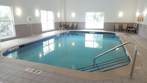 An indoor swimming pool with clear water, tiled walls, and windows allowing natural light. - Hampton Inn Heath-Newark (Heath)