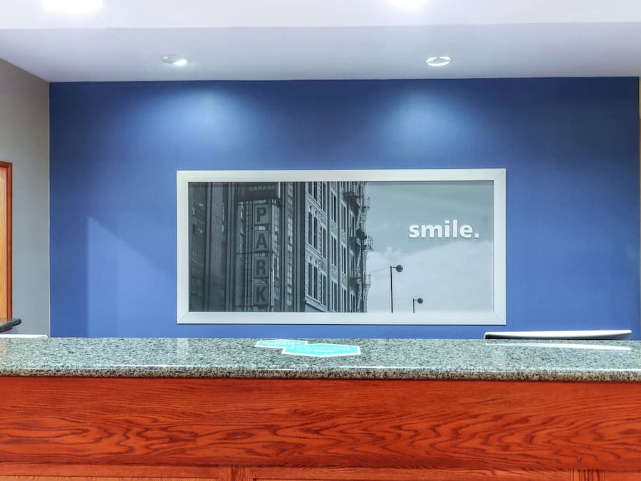 Un área de recepción con una pared azul, un cuadro enmarcado y un mostrador de madera.