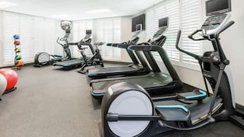 A gym with multiple treadmills, exercise balls, and a stationary bike.