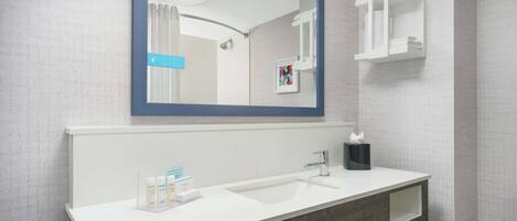 Une salle de bain avec un lavabo blanc, un miroir et un porte-serviettes.
