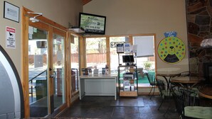 A restaurant interior with a counter, seating area, and a television mounted on the wall.