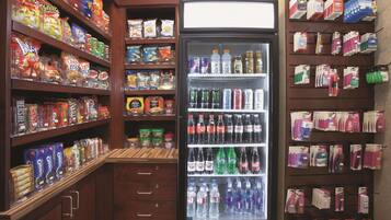 A grocery store with shelves stocked with snacks, beverages, and household items.