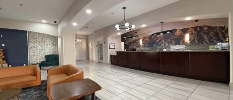 A modern reception area with a reception desk, seating area, and a patterned wall.