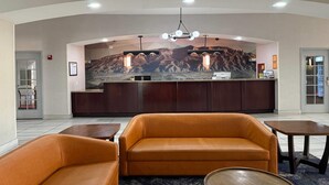 A reception area with a mountain mural, a reception desk, and seating arrangements. - La Quinta Inn & Suites by Wyndham Albuquerque Midtown (Albuquerque)