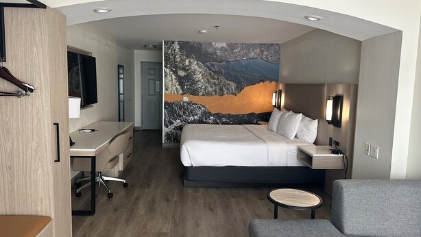 A modern hotel room with a large bed, a desk, a chair, and a small table. - La Quinta Inn & Suites by Wyndham Albuquerque Midtown (Albuquerque)