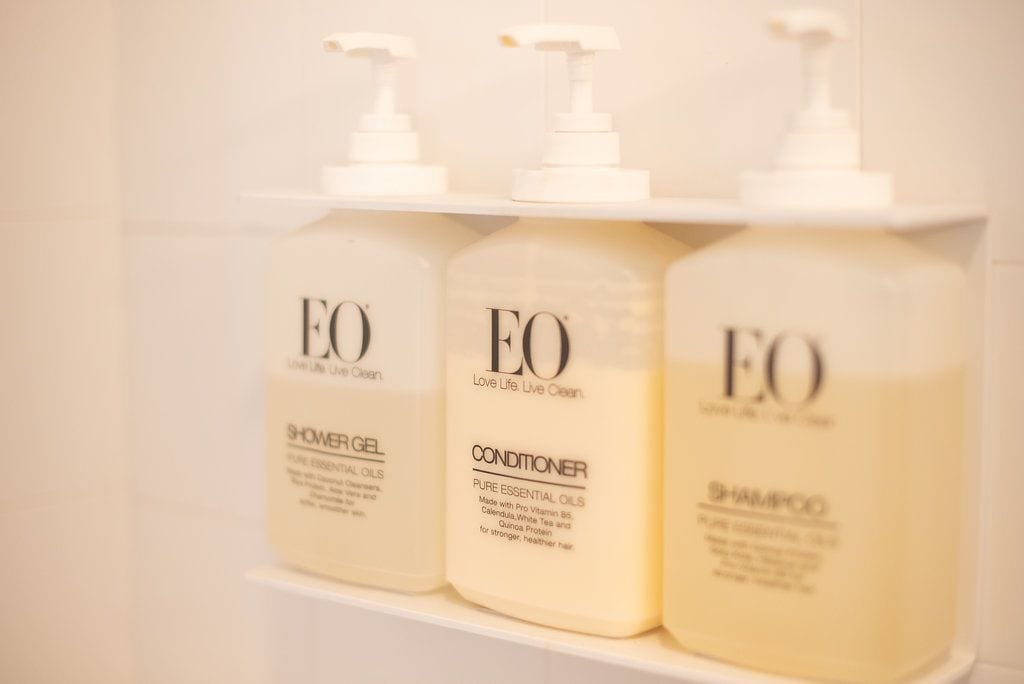 Tres botellas de productos EO sobre una estantería.