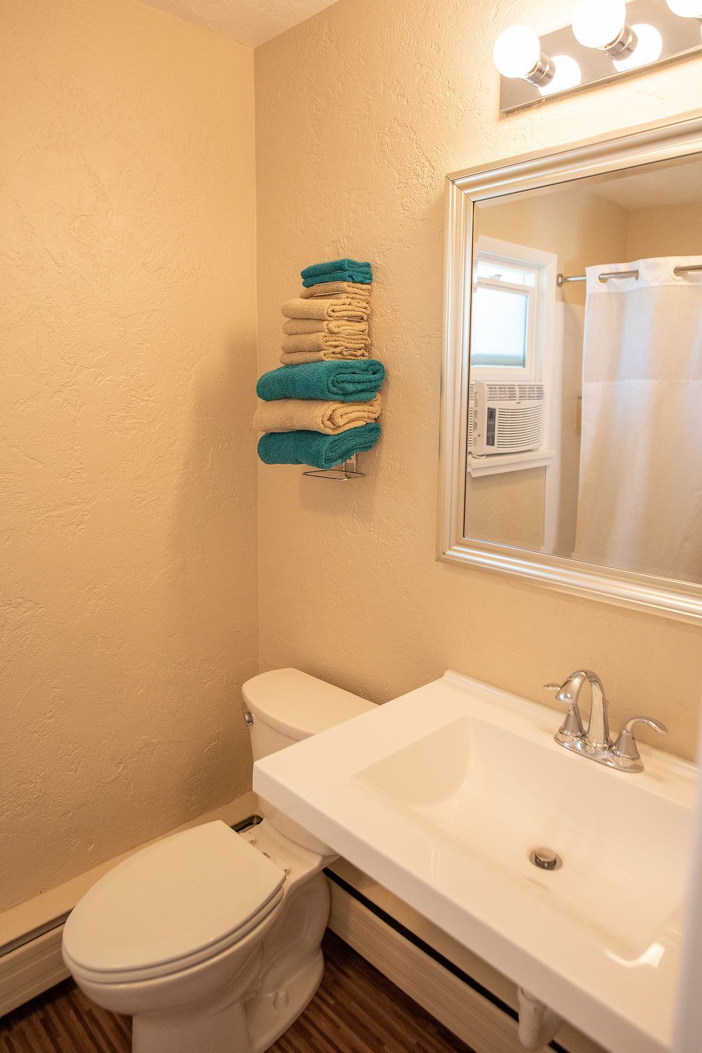 A bathroom with a toilet, sink, and towel rack.