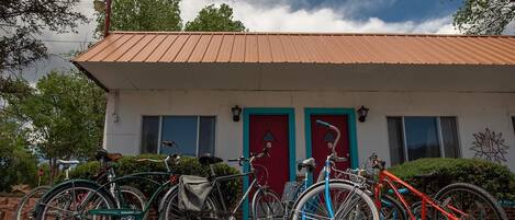 A building with a red door and a bike rack with several bicycles parked in front.