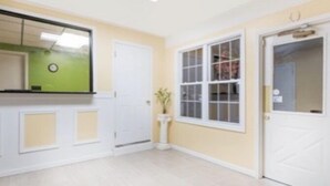 A room with a kitchenette, a door, and a window. - Budget Inn (Mifflintown)
