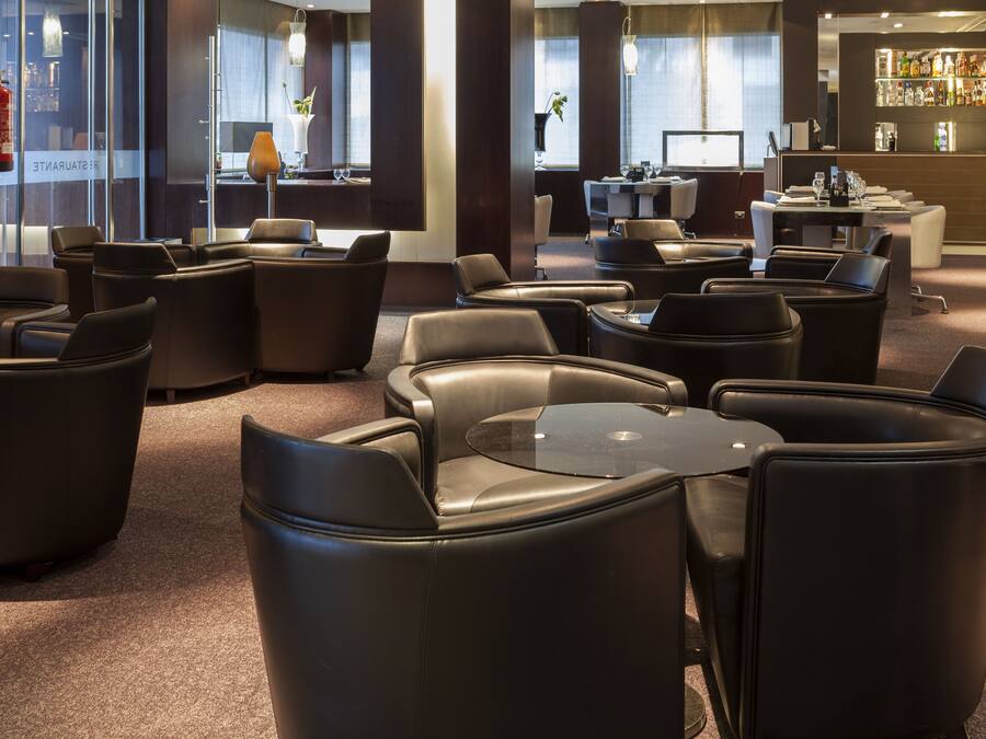 Un hall de hotel con asientos de cuero, una recepción y una zona de bar.
