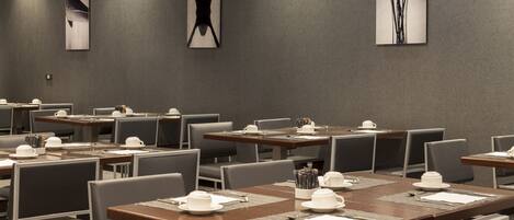 A conference room with multiple tables set for meetings, equipped with nameplates, notepads, and pens.