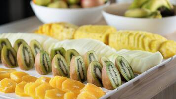 A tray of sliced fruits including kiwi, mango, and banana.