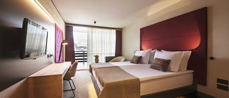 Une chambre d’hôtel moderne, équipée d’un lit, d’un bureau et d’une chaise.