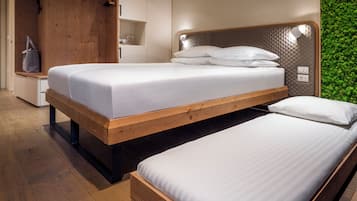 Un dormitorio moderno con dos camas individuales, cabeceros de madera y una pared verde.