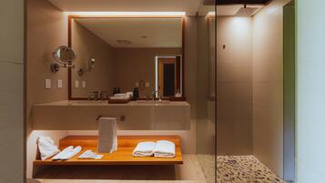 A modern bathroom with a wooden bench, a large mirror, and a shower area.