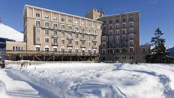Stunning mountain hotel with a classic facade, featuring evenly spaced windows and balconies.