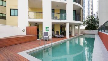 Alberca al aire libre y camastros