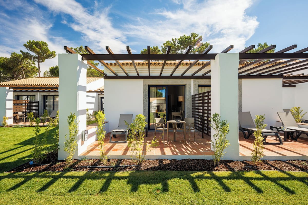 Une terrasse extérieure moderne, dotée d’une pergola, d’un espace salon et offrant une vue sur l’immeuble voisin.