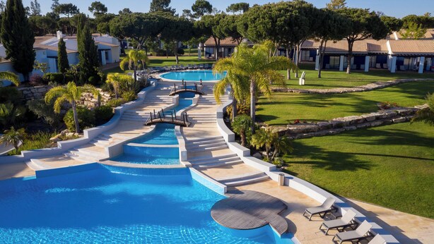 A resort with a large swimming pool, a winding water feature, and a well-maintained lawn. - Pestana Vila Sol Golf - Vilamoura (Loulé)