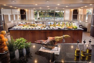 A buffet with various food items and a roasted pig centerpiece.