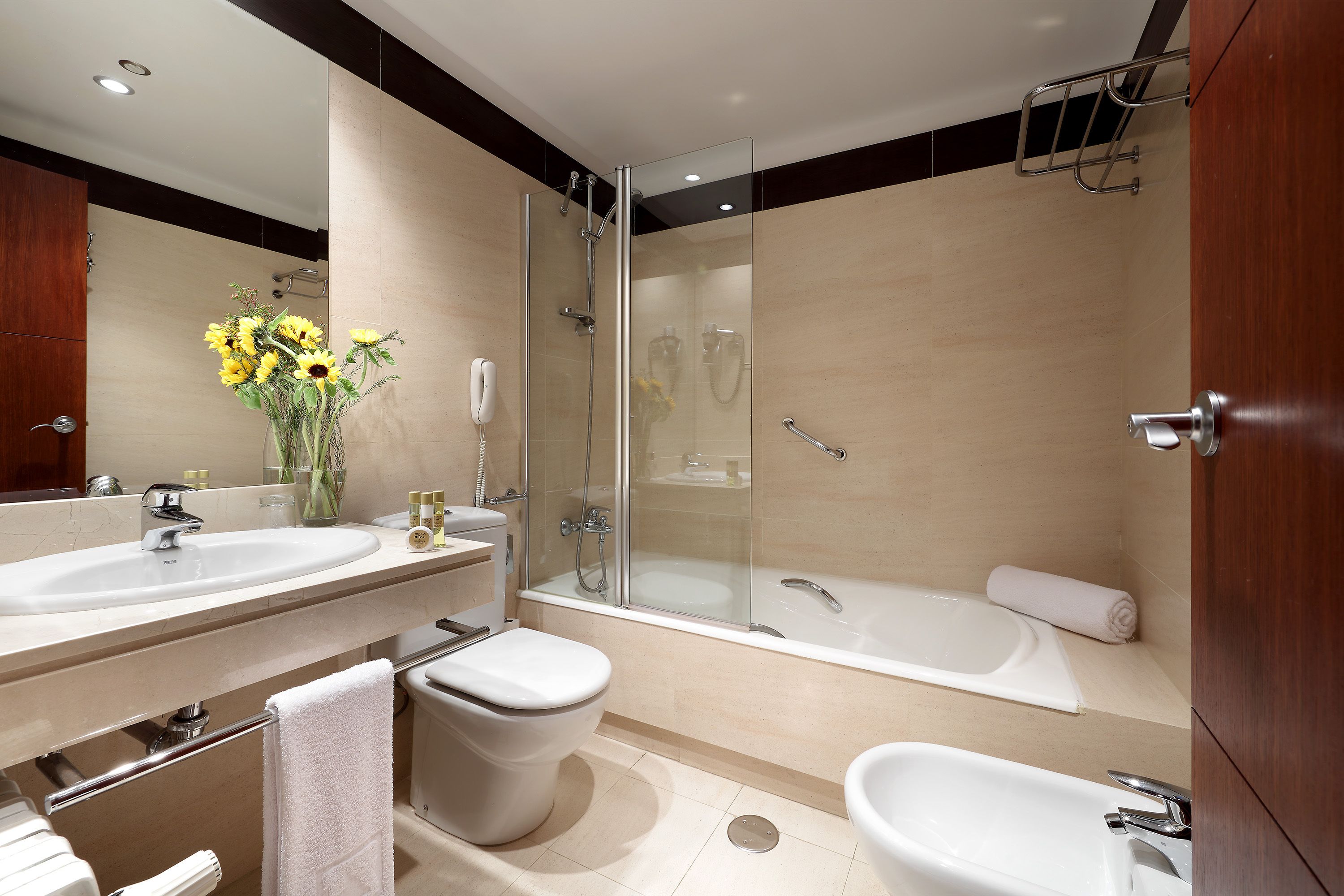 A modern bathroom with a glass-enclosed shower, a bathtub, a toilet, and a sink.