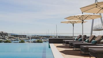 Piscine couverte, piscine extérieure, parasols de plage, chaises longues