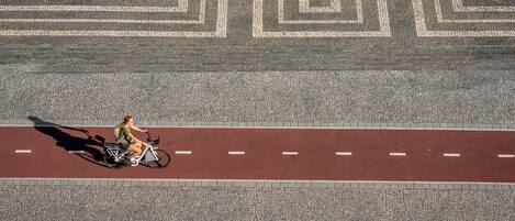 Una persona montando en bicicleta sobre una carretera con un patrón geométrico marcado.