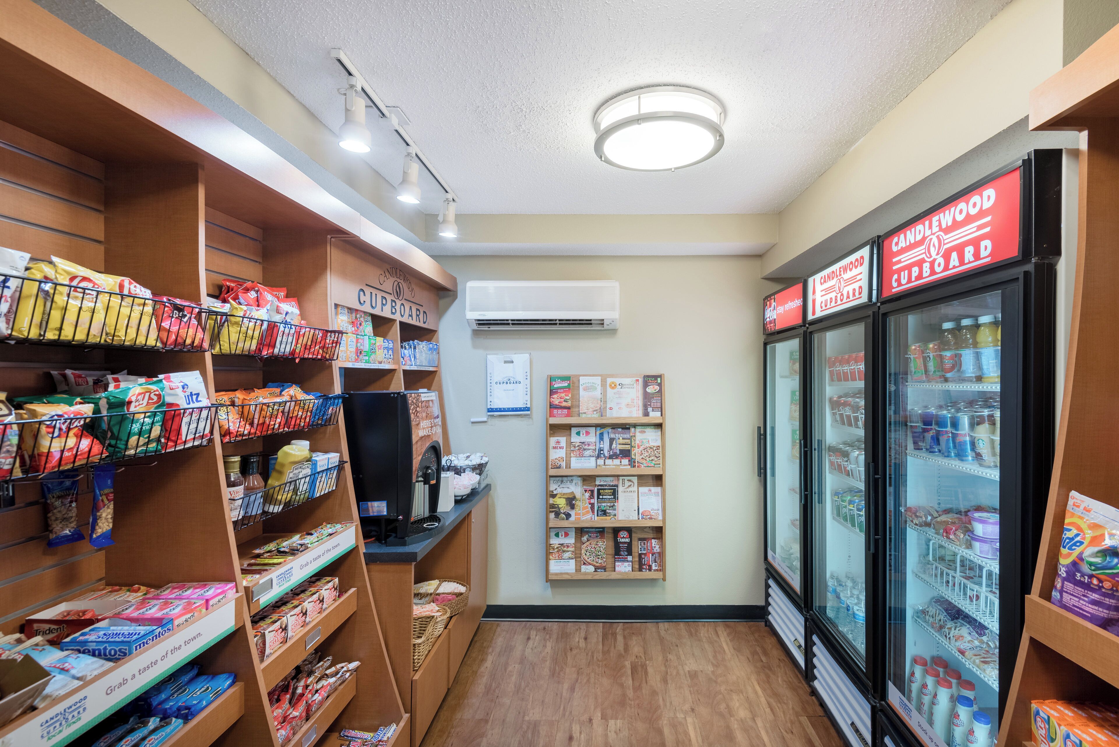 Une épicerie de proximité avec des étagères remplies d’en-cas, un distributeur de café et un réfrigérateur vitrine.