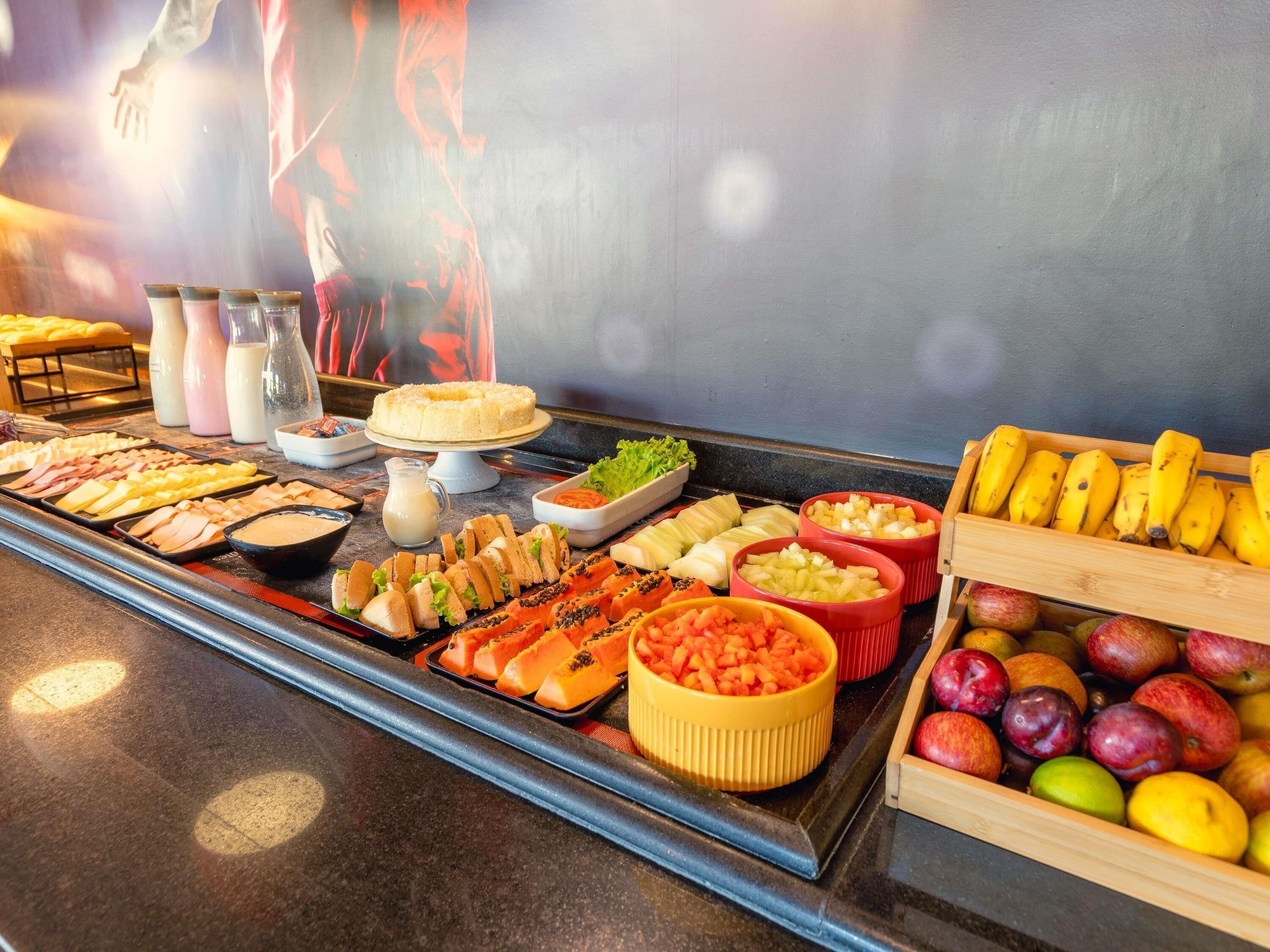Een buffet met diverse soorten eten, zoals fruit, groenten en belegde broodjes.