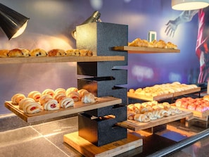 A display of pastries on tiered wooden stands with a modern design. - ibis Sao Paulo Interlagos (São Paulo)