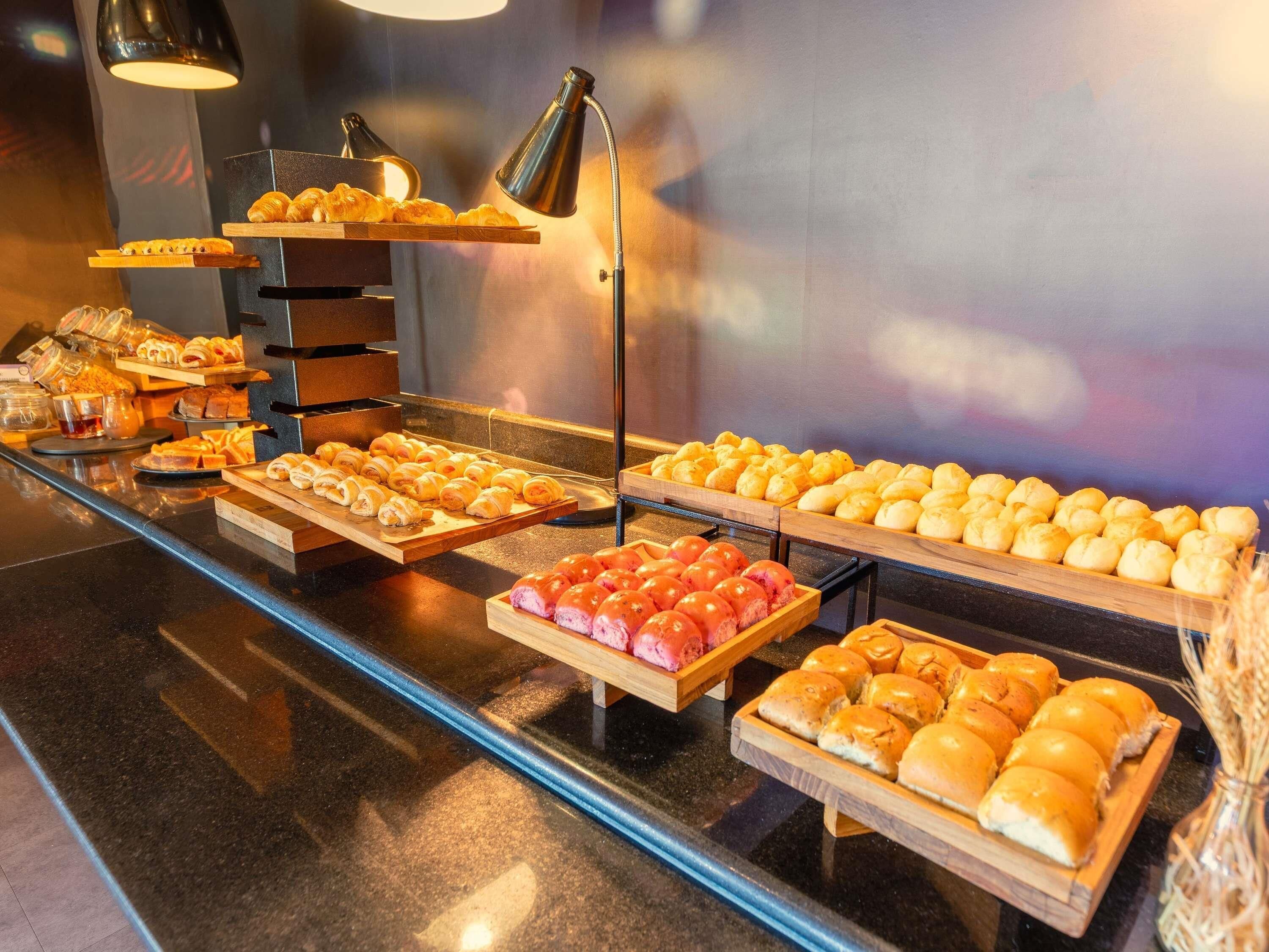 A buffet with various baked goods, including pastries and bread, displayed on wooden boards.