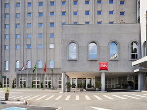 Un hotel con fachada moderna, múltiples ventanales y el logotipo destacado de ibis.