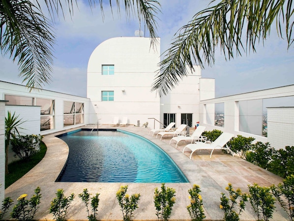 Enjoy a refreshing dip in the pool surrounded by palm trees and take in the stunning city views.