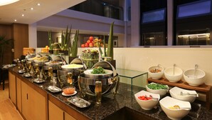 Ein Buffet mit verschiedenen Speiseauslagen und einer Glaskuppel für Früchte.