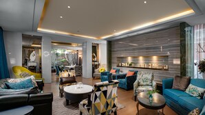 Ein modernes Wohnzimmer mit verschiedenen Sitzgelegenheiten, darunter Sofas und Sessel, die um einen zentralen Couchtisch angeordnet sind.