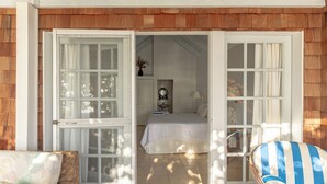 An open door leading to a bedroom with a bed, a chair, and a small table. - Fort Recovery Beachfront Resort (West End)