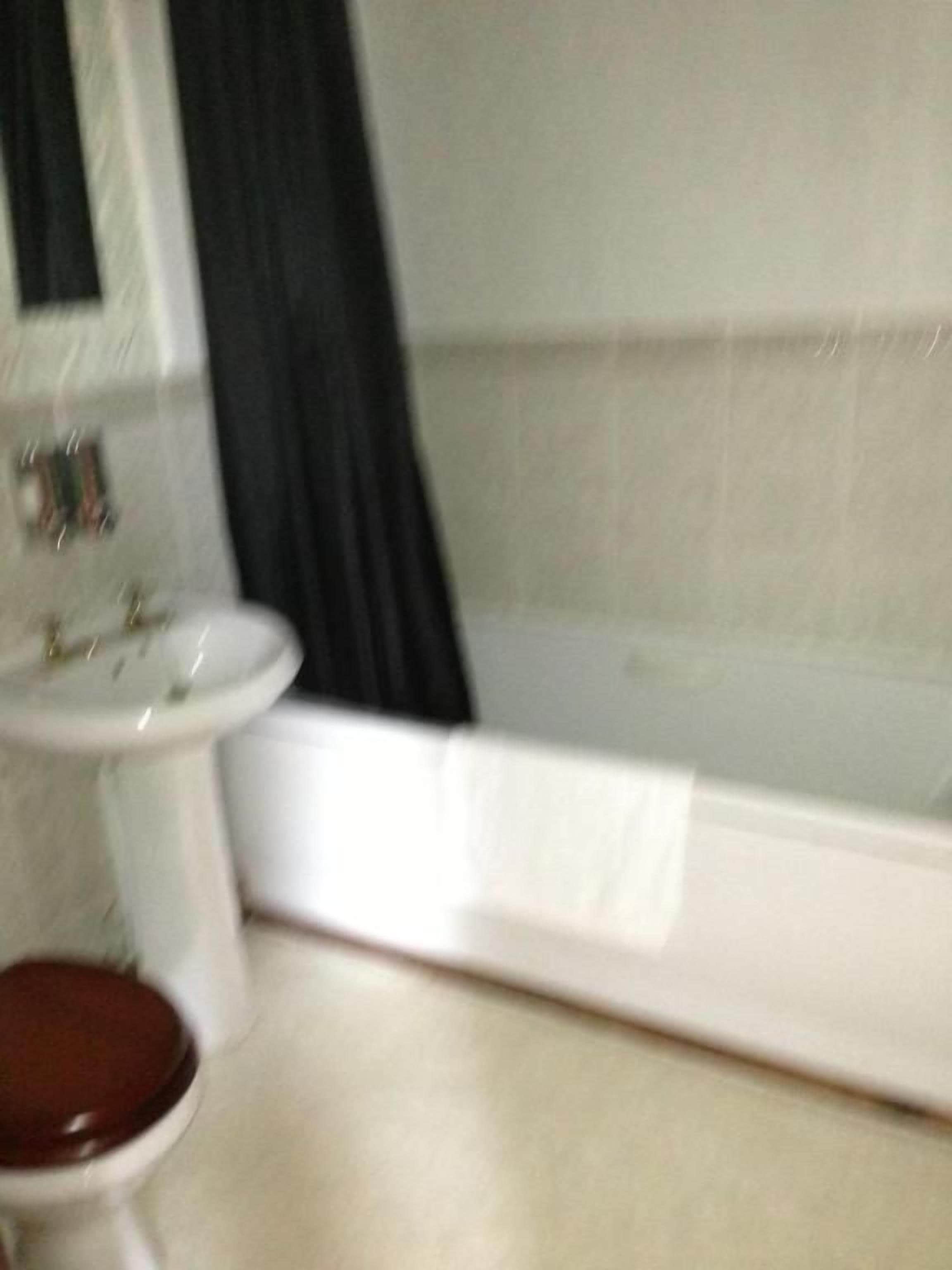 A bathroom with a toilet, sink, and bathtub.
