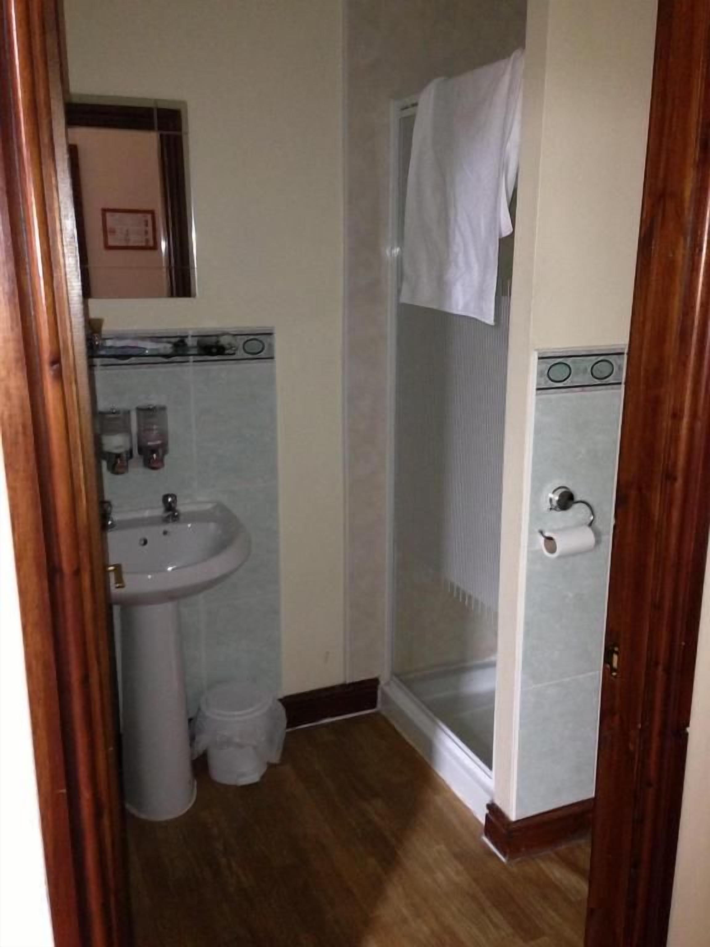 A bathroom with a sink, toilet, and shower.