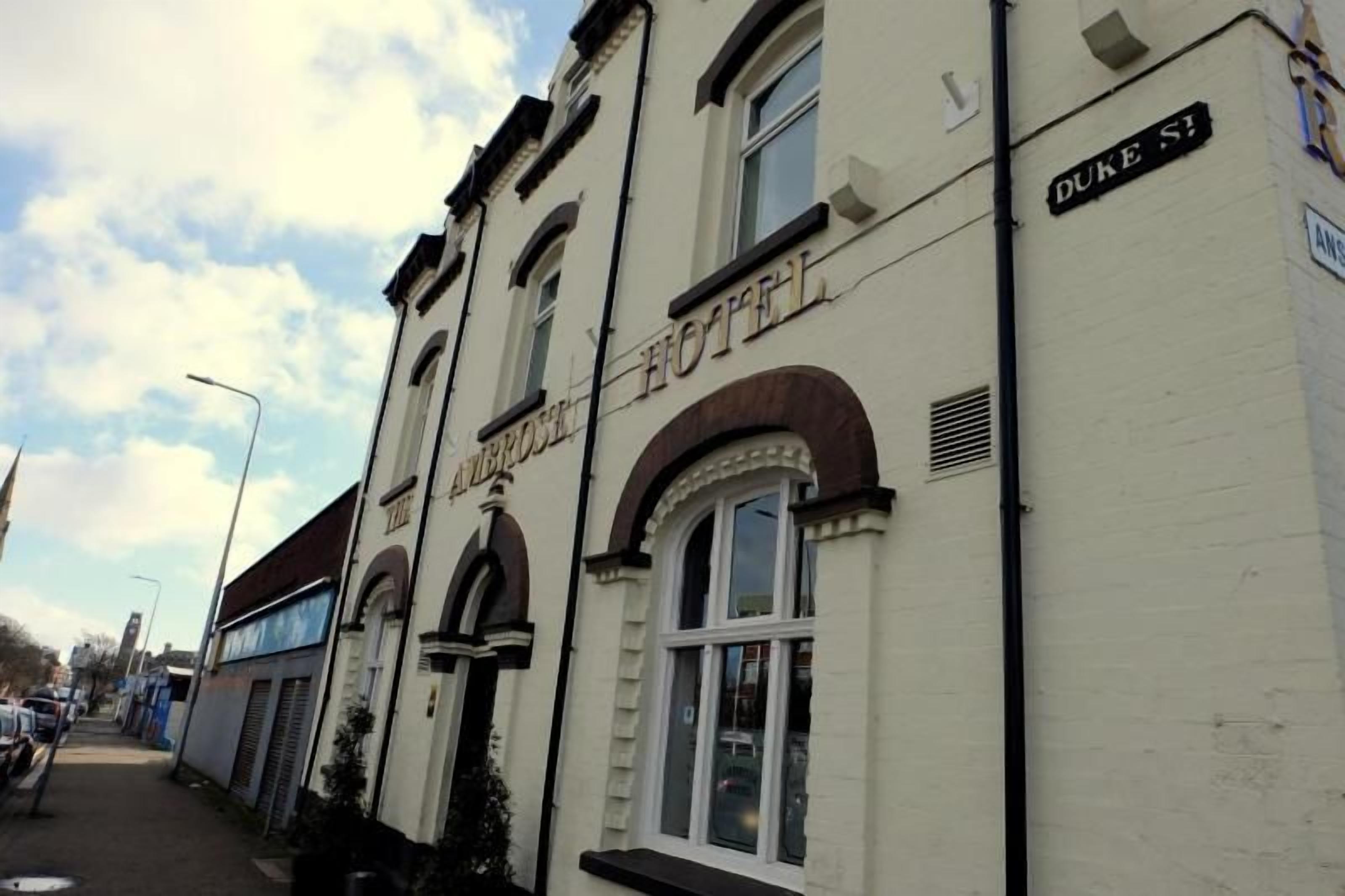 A building with 'The Ambrose Hotel' sign, Duke Street address, and a traditional architectural style with arched windows.