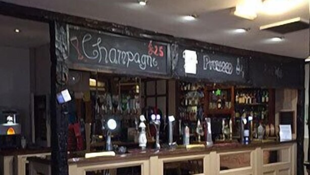 A bar area with a counter, bar stools, and a sign reading "Champagne".