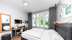 Una habitación de hotel moderna con una cama grande, un escritorio, una silla y un televisor.