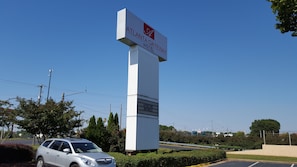 Um letreiro alto e branco com o logotipo do Atlanta Gateway Hotel e a frase 'ABERTO PARA NEGÓCIOS'.