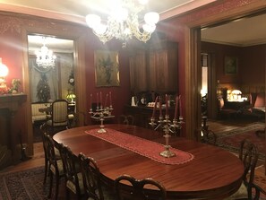 A formal dining room with a wooden table, chairs, a chandelier, and a red carpet. - The Gables B&B Philadelphia (Philadelphia)