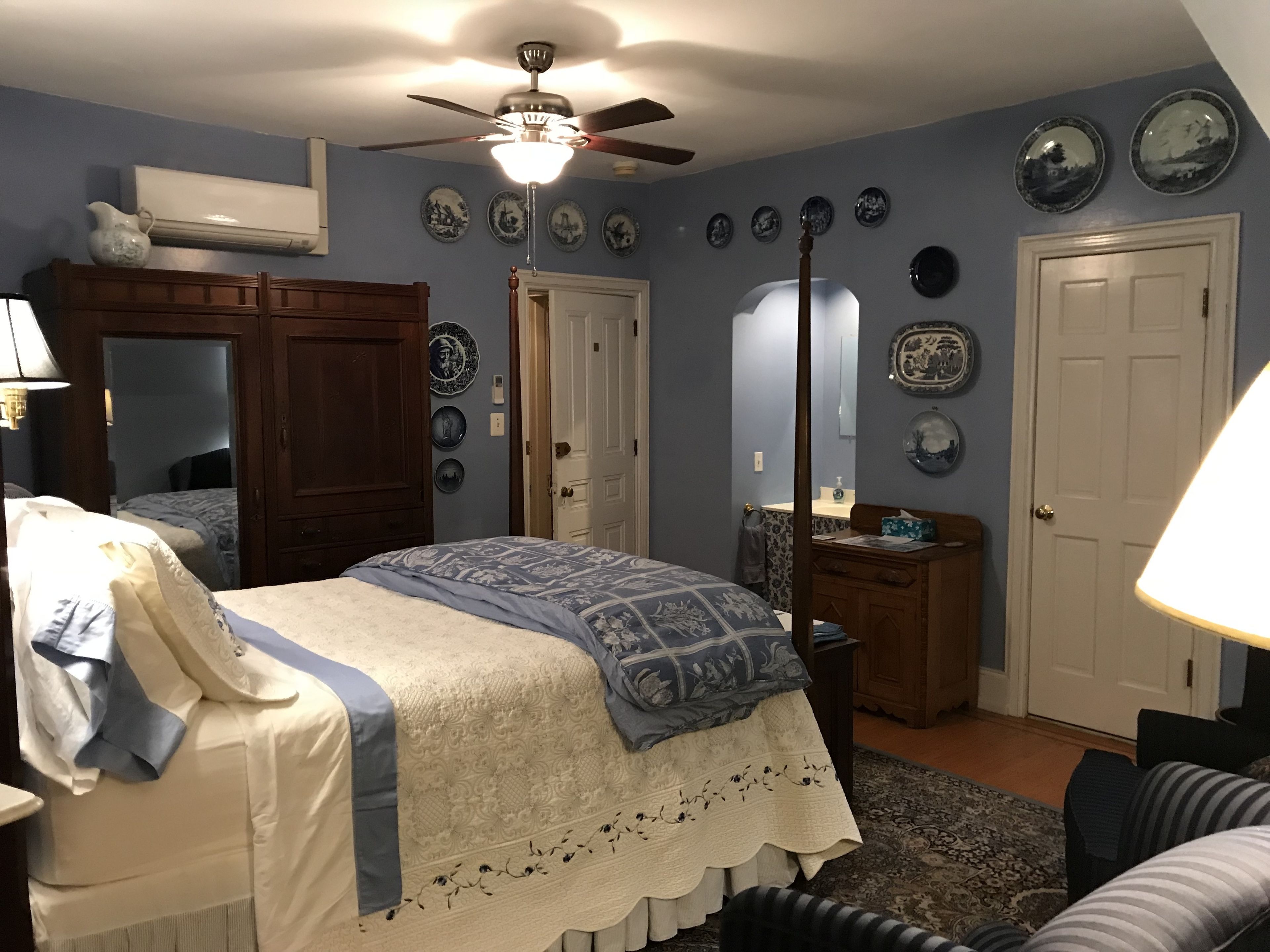 Une chambre à coucher avec un lit, une commode et un ventilateur de plafond.