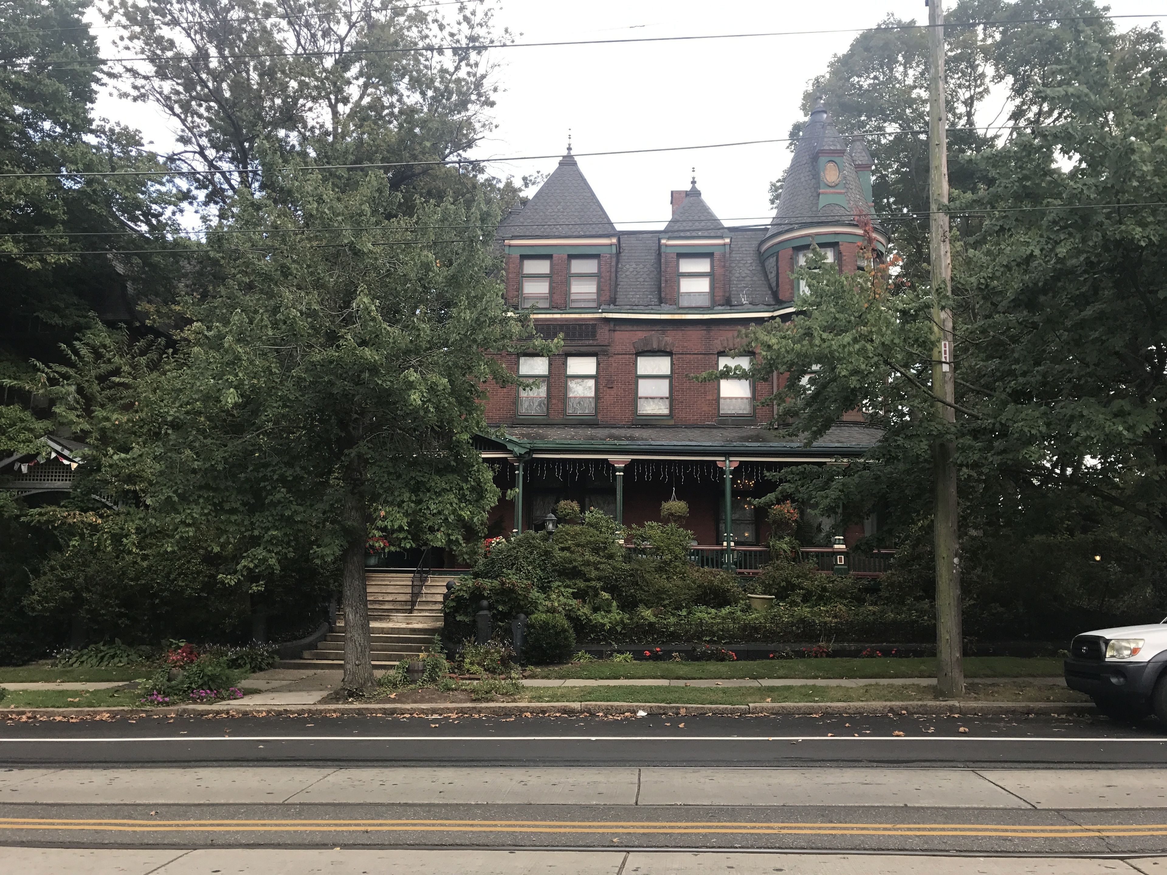 Et victoriansk hus med en markant veranda, facade i mursten og et stejlt tag.