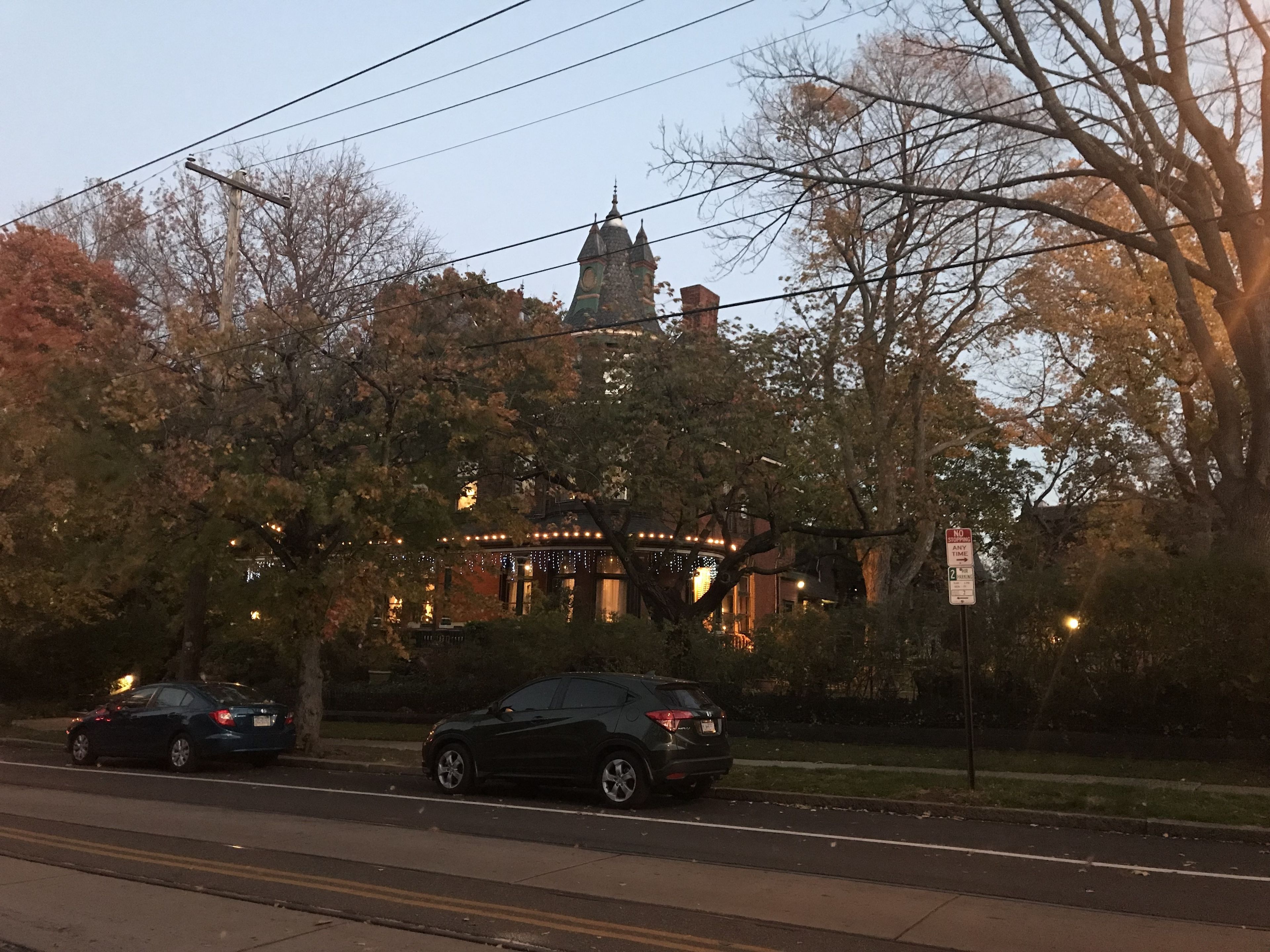 A building with a tower, surrounded by trees and streetlights.