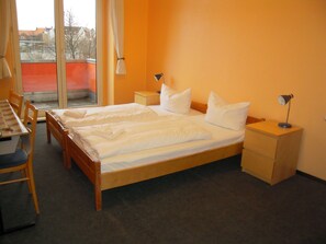 A hotel room with a large bed, two bedside tables, a desk, and a chair. - HappyGoLucky Hotel & Hostel (Berlin)